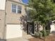 Brick two-story townhome with a single car garage and a well-manicured lawn at 1650 Larkspur Trl, Conyers, GA 30012