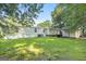 Exterior home view featuring a sprawling lawn bordered by mature trees, creating a private backyard oasis at 340 Loblolly Rdg, Locust Grove, GA 30248