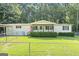 Charming single-story home featuring a quaint porch, green lawn, and fenced yard at 340 Loblolly Rdg, Locust Grove, GA 30248