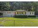 Charming single-story home featuring a quaint porch, green lawn, and fenced yard at 340 Loblolly Rdg, Locust Grove, GA 30248