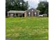 Traditional-style home with brick facade, mature trees, and well-manicured front lawn at 955 Foxworthy Ln, Riverdale, GA 30296