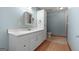 Bright bathroom featuring white vanity, matching mirror, and a convenient built-in storage cabinet at 207 Conkle Rd, Hampton, GA 30228