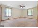 Bright bedroom featuring a fan, carpeted floors, with natural light streaming through the windows at 207 Conkle Rd, Hampton, GA 30228