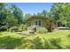Home exterior featuring a lush green yard, landscaping and mature trees at 207 Conkle Rd, Hampton, GA 30228
