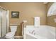 Bright bathroom with soaking tub, tiled surround, toilet, shower, and tan walls at 286 Prominent Loop, Mcdonough, GA 30253