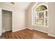 Bright bedroom featuring a vaulted ceiling, arched window, wood-look flooring and walk-in closet at 286 Prominent Loop, Mcdonough, GA 30253