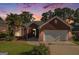 Charming brick home with a well-manicured lawn at dusk, and a two-car garage at 286 Prominent Loop, Mcdonough, GA 30253