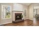 A cozy fireplace with a brick hearth, white mantel, and a glass door to the outside at 286 Prominent Loop, Mcdonough, GA 30253