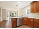 Well-lit eat-in kitchen features stainless steel dishwasher, wood cabinets, and white countertops at 286 Prominent Loop, Mcdonough, GA 30253