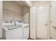 Laundry room featuring white washer and dryer, wire shelving, and door at 286 Prominent Loop, Mcdonough, GA 30253