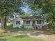 Cozy one-story home featuring a welcoming front porch and ample shade trees at 443 Walker St, Villa Rica, GA 30180