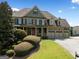 Charming brick home with meticulously manicured landscaping, a welcoming front porch, and a spacious three-car garage at 5585 Lavender Farms, Powder Springs, GA 30127