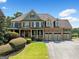 Beautiful, two-story brick home with an inviting porch and three-car garage offers fantastic curb appeal at 5585 Lavender Farms, Powder Springs, GA 30127