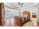 Bright main bedroom featuring a ceiling fan, tray ceiling, and entry to the main bathroom at 5585 Lavender Farms, Powder Springs, GA 30127