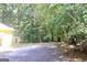 Wide driveway that leads to the back and side of the house, surrounded by lush trees at 150 Ashley Dr, Fayetteville, GA 30214