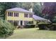 Inviting two-story yellow home featuring red shutters and well-maintained landscaping at 150 Ashley Dr, Fayetteville, GA 30214