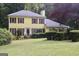 Attractive yellow home with red shutters surrounded by lush greenery at 150 Ashley Dr, Fayetteville, GA 30214