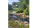Picturesque pond with natural rock waterfall, lush greenery, and serene water features, creating a peaceful outdoor retreat at 150 Ashley Dr, Fayetteville, GA 30214