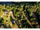 Stunning aerial view of home with mature trees, river, and an accessory building at 1051 Lake Rutledge Rd, Rutledge, GA 30663