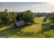 Aerial view of a barn with fenced pasture, surrounded by mature trees and green fields at 1051 Lake Rutledge Rd, Rutledge, GA 30663