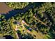 Aerial view of home nestled in mature trees, with river and accessory structures at 1051 Lake Rutledge Rd, Rutledge, GA 30663