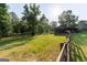 Open air barn surrounded by green pasture and a wooden fence under blue skies at 1051 Lake Rutledge Rd, Rutledge, GA 30663