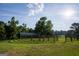 Open air barn with metal roof surrounded by green grass and a wooden fence at 1051 Lake Rutledge Rd, Rutledge, GA 30663