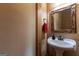 Bathroom with rustic-style wooden frame mirror, white sink, and a red towel at 1051 Lake Rutledge Rd, Rutledge, GA 30663