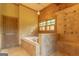 Bathroom showing a jacuzzi tub, decorative tile, and wood paneling at 1051 Lake Rutledge Rd, Rutledge, GA 30663