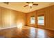 Cozy bedroom with wood-paneled walls, windows with blinds, and wood floors at 1051 Lake Rutledge Rd, Rutledge, GA 30663