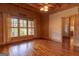 Wood-paneled bedroom with a ceiling fan, window, and a doorway leading to another room at 1051 Lake Rutledge Rd, Rutledge, GA 30663
