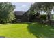 Beautiful home with green lawn, matching shed, and a wooden fence at 1051 Lake Rutledge Rd, Rutledge, GA 30663