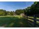 Beautiful home exterior with mature trees, green grass, and fenced pasture at 1051 Lake Rutledge Rd, Rutledge, GA 30663