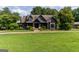 Inviting home with stone accents, a large yard, and well-maintained landscaping at 1051 Lake Rutledge Rd, Rutledge, GA 30663