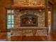 Close-up of the stone fireplace featuring a substantial log mantle, and hearth in cozy living space at 1051 Lake Rutledge Rd, Rutledge, GA 30663