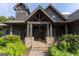 Inviting front entrance with stone steps leading to a covered porch with sturdy timber posts at 1051 Lake Rutledge Rd, Rutledge, GA 30663