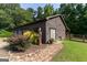 Garage exterior featuring a vintage gas pump, stone walkway, and well-maintained landscaping at 1051 Lake Rutledge Rd, Rutledge, GA 30663