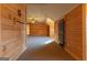 Hallway featuring wood-paneled walls leading into a large bonus room with a ceiling fan at 1051 Lake Rutledge Rd, Rutledge, GA 30663
