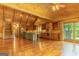 Spacious living area showcasing hardwood floors, vaulted wood ceilings, and a well-equipped kitchen with stainless steel appliances at 1051 Lake Rutledge Rd, Rutledge, GA 30663