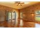 Spacious living room with wood paneling, ceiling fan, hardwood floors, and plenty of natural light at 1051 Lake Rutledge Rd, Rutledge, GA 30663