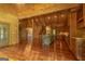 Open-concept living room with hardwood floors, vaulted wood ceilings, and a modern kitchen with stainless steel appliances at 1051 Lake Rutledge Rd, Rutledge, GA 30663