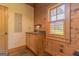 Wood-paneled mud room featuring a sink, window, stone floors, and a door at 1051 Lake Rutledge Rd, Rutledge, GA 30663