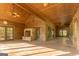 Spacious wooden porch featuring a stone fireplace, ceiling fans, and ample natural light at 1051 Lake Rutledge Rd, Rutledge, GA 30663