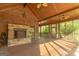 Inviting covered porch features a stone fireplace, ceiling fans, and screened openings to the outdoors at 1051 Lake Rutledge Rd, Rutledge, GA 30663