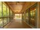 Long, screened-in porch with wooden floors, ceiling fans, and multiple access points at 1051 Lake Rutledge Rd, Rutledge, GA 30663