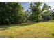 Lush green yard with mature trees offers privacy and a peaceful setting at 1051 Lake Rutledge Rd, Rutledge, GA 30663