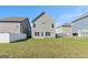 The backyard features green grass with the home's rear exterior and a white fence at 2384 Hastings Manor Ln, Hampton, GA 30228