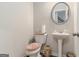 Powder room features a pedestal sink, round mirror and neutral decor at 2384 Hastings Manor Ln, Hampton, GA 30228