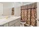 Clean bathroom featuring vinyl floors, a white vanity, toilet, and patterned shower curtain at 2384 Hastings Manor Ln, Hampton, GA 30228