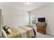 Bright bedroom features carpet, a window and a dark wood dresser with a TV at 2384 Hastings Manor Ln, Hampton, GA 30228